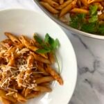 Tomato pasta served with parsley and grated parmesan cheese