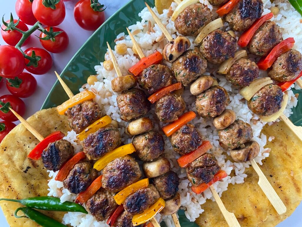 Tasty shish lamb kofte served with cherry tomatoes, chilli peppers, wrap bread and pilaf rice