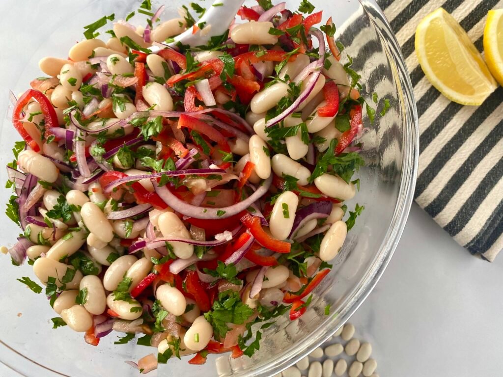 Vegan cannellini bean (white bean) salad bowl served with lemon wedges