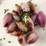 Air fryer shallots with chives sprinkled on top.