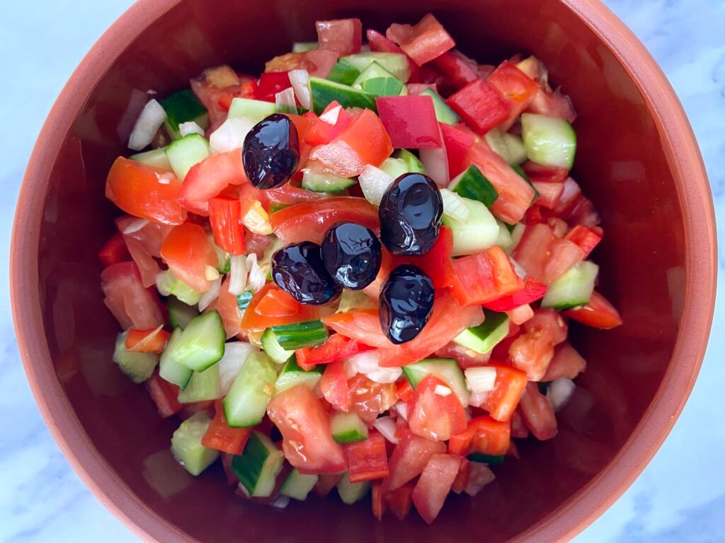 Shepherd's salad with black olives on top.