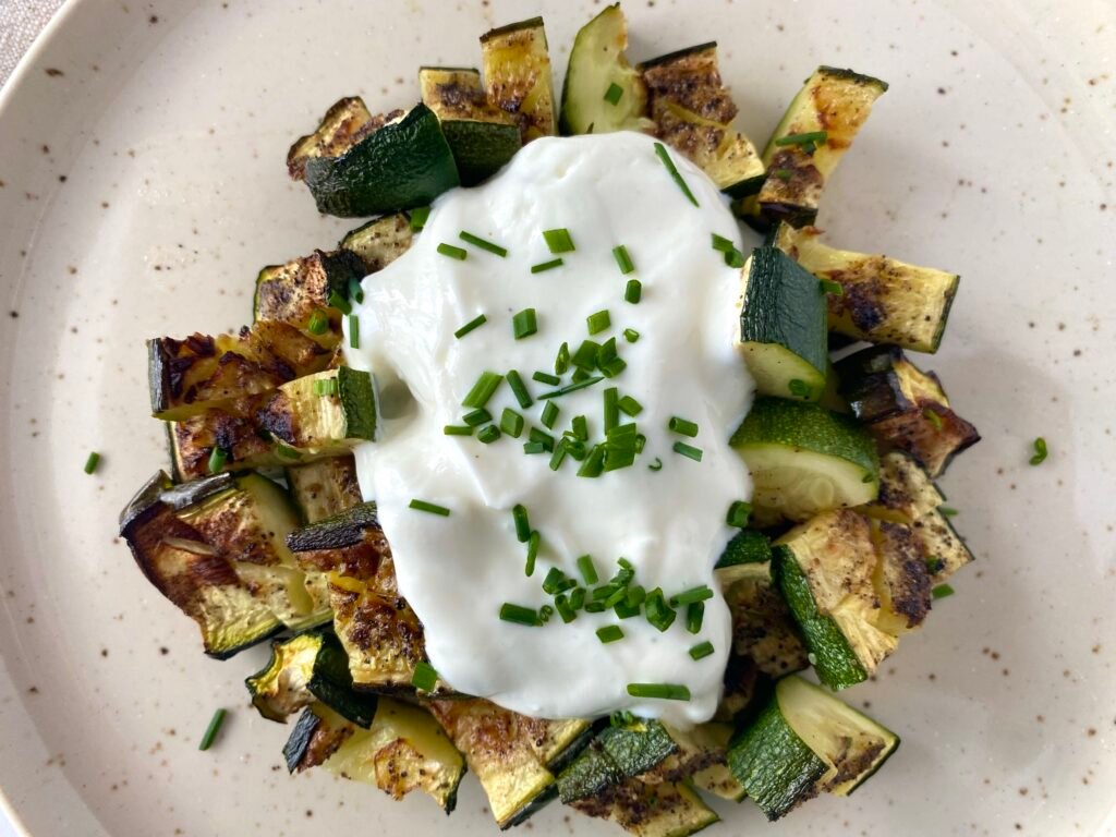 Air fryer courgette zucchini recipe with garlic Greek yoghurt and chives.