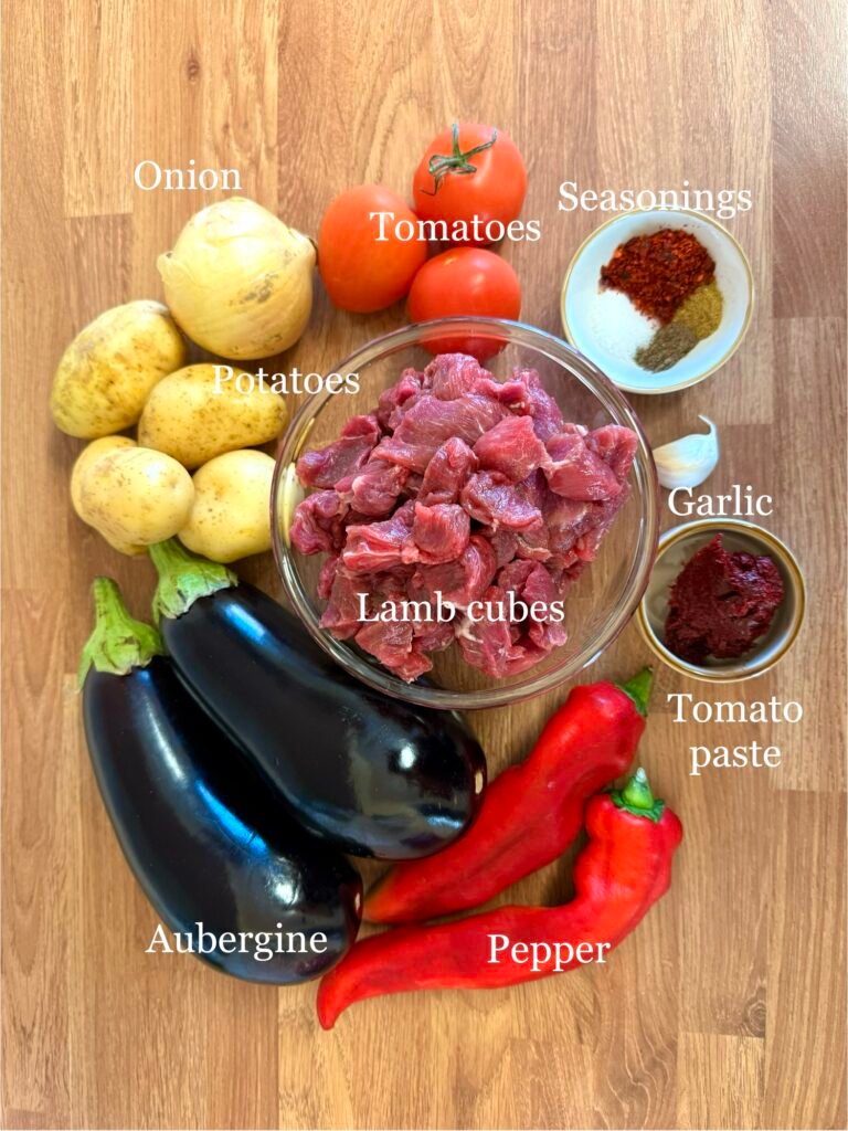 Ingredients for one-pot lamb and aubergine stew: aubergine/eggplant, onion, pepper, potato, lamb, tomatoes, seasonings, red pepper paste and garlic.