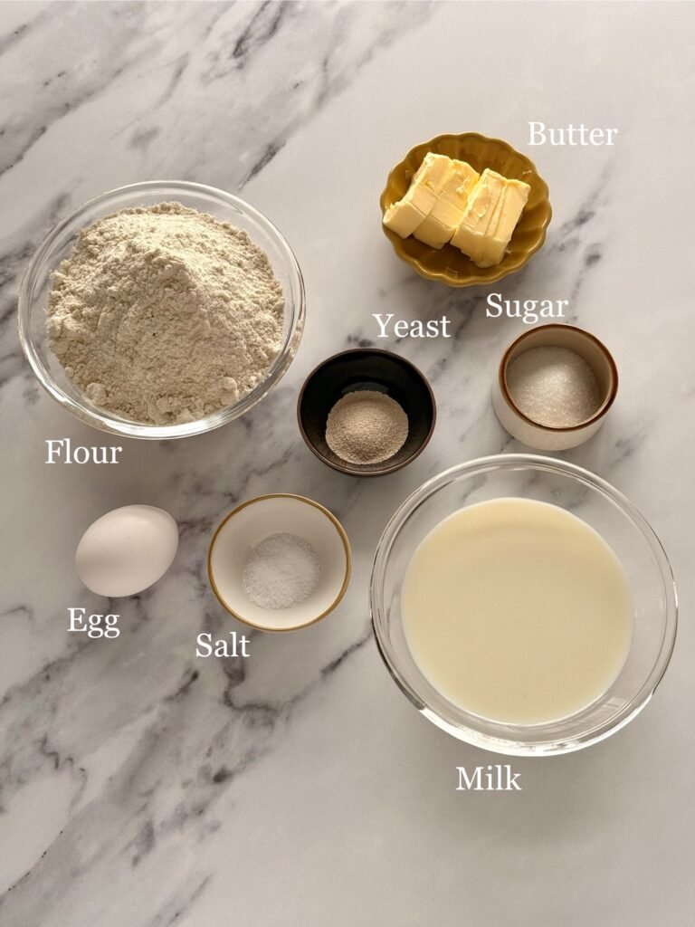 Ingredients for homemade bread rolls, perfect for Thanksgiving: flour, yeast, sugar, salt, butter, and an egg.