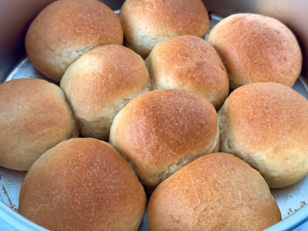 A batch of freshly baked, golden-brown dinner rolls, perfect for Thanksgiving celebrations.