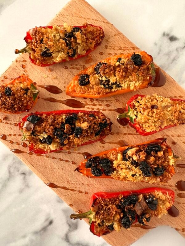 Stuffed mini red peppers with walnuts and raisins and drizzled with pomegranate molasses